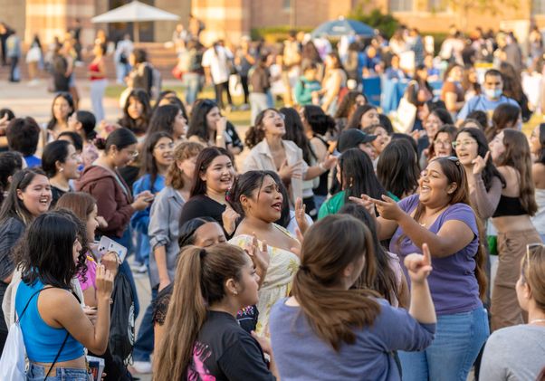 Large crowd of students dancing and singing in Wilson Plaza