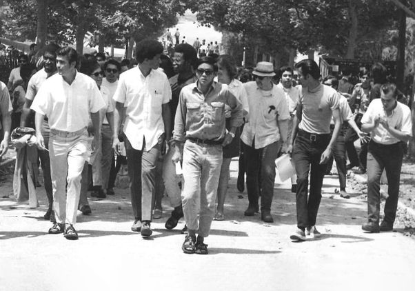 Black-and-white photo of Morgan Chu (front) marching with other students at UCLA in the 1960s