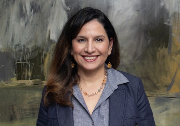 Mid-range portrait of Athena Jackson in front of painting