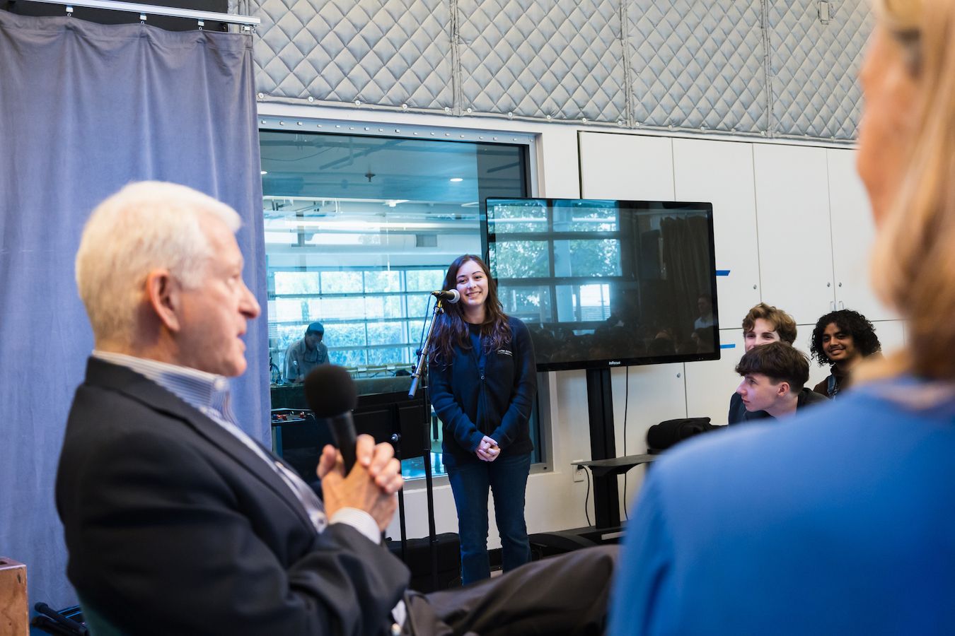 Student standing at microphone to ask a question