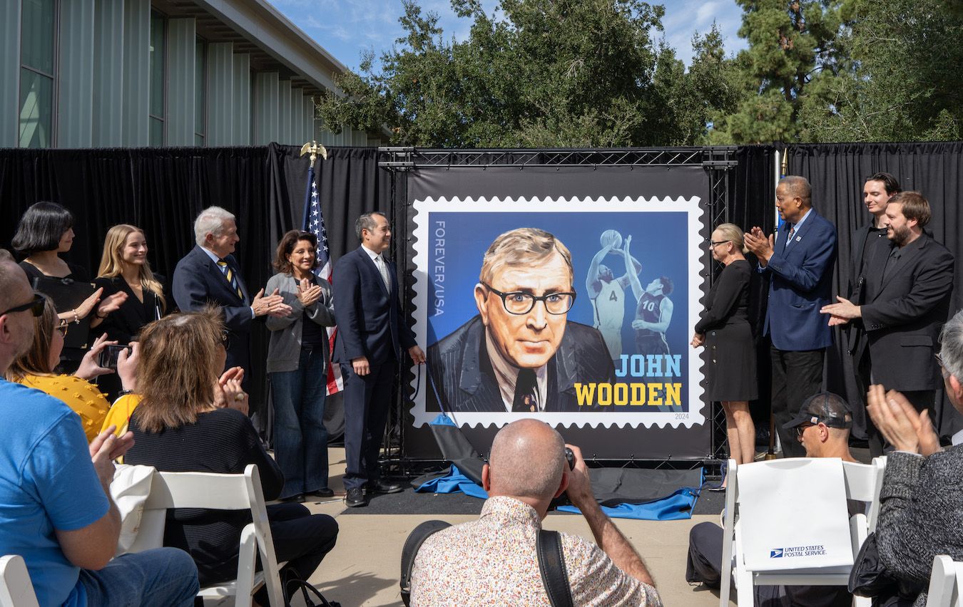 Group flanking enlarged John Wooden stamp at UCLA ceremony