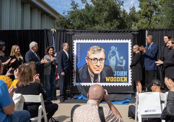 Group flanking enlarged John Wooden stamp at UCLA ceremony