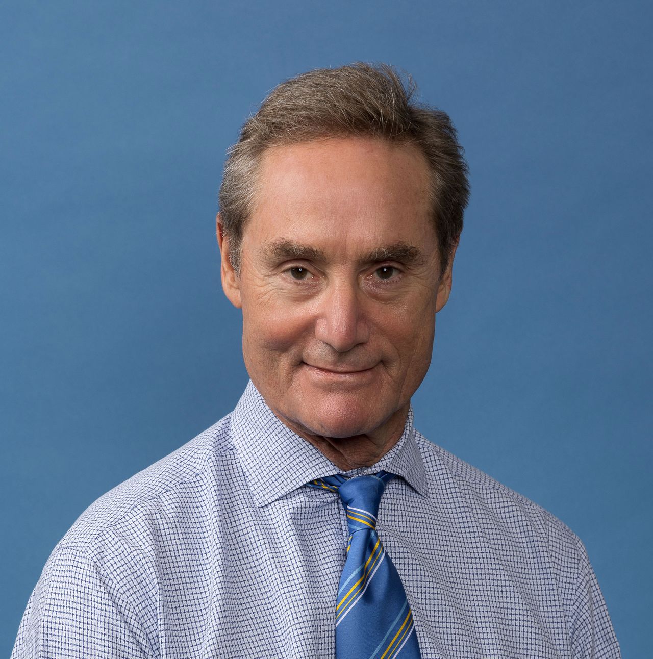 Robert Wilder wearing shirt with blue-and-yellow tie