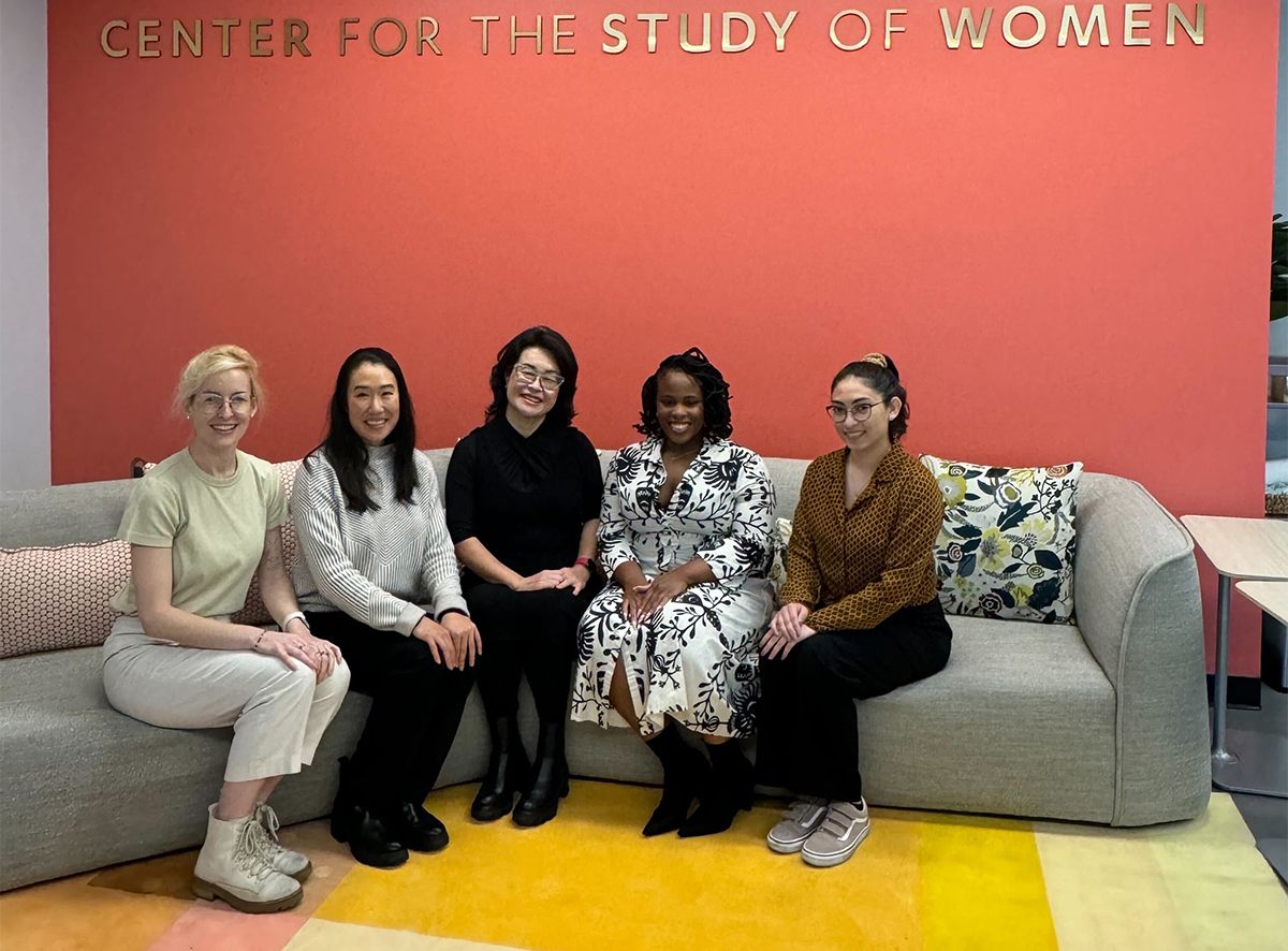 Group of five sitting below Center for Study of Women sign