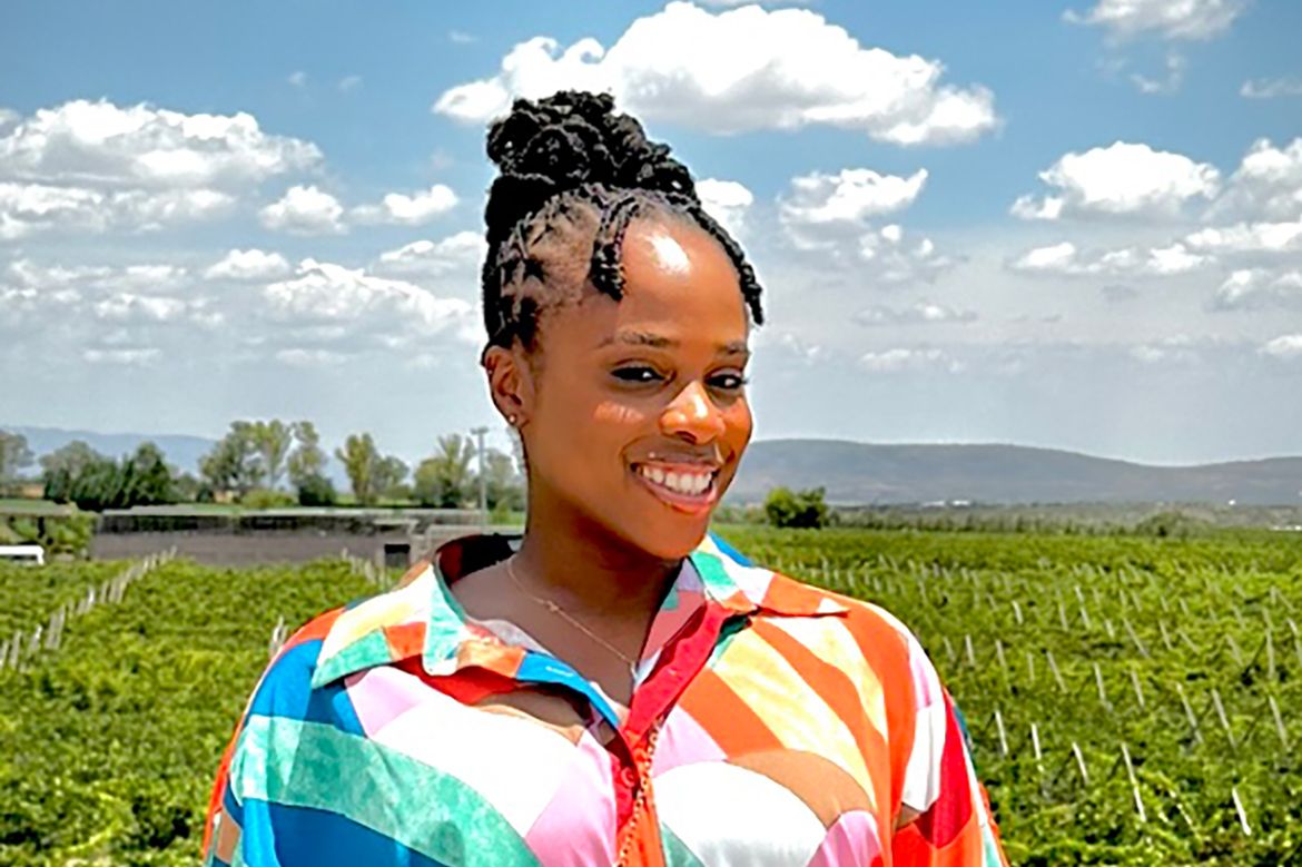Lynette Dixon in colorful top in front of crops