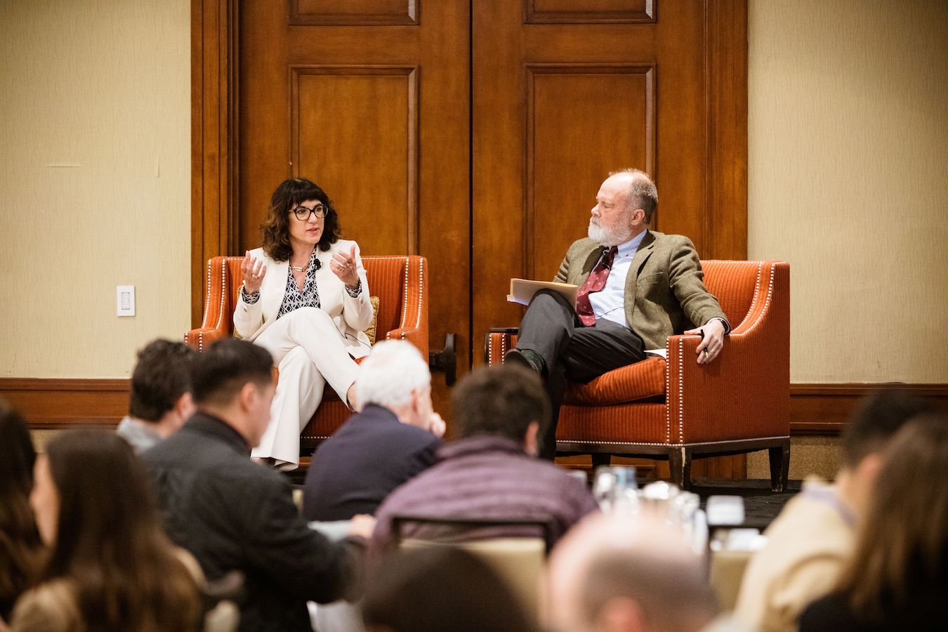 Jenna Hornstock Los Angeles’ deputy mayor of housing (left), and UCLA’s Jim Newton sit in chairs on stage during their discussion about homelessness in Los Angeles