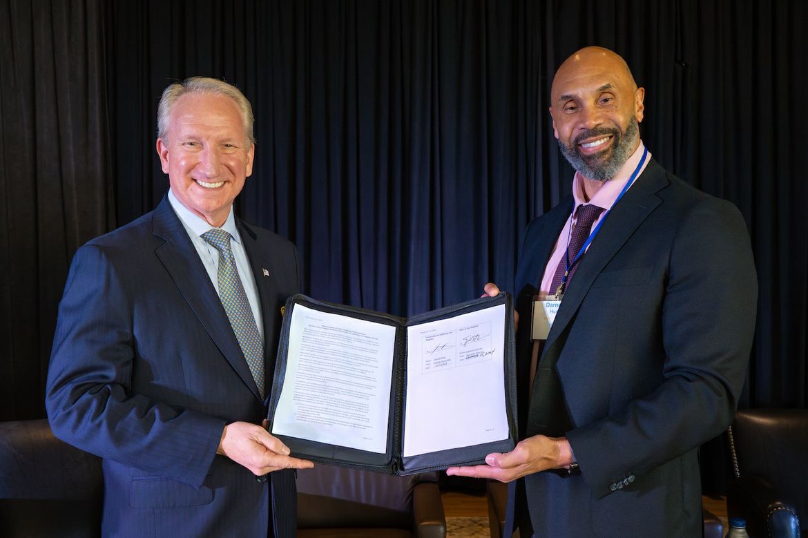 Gene Seroka, executive director of the Port of Los Angeles (left), and Darnell Hunt, UCLA’s interim chancellor hold the memorandum of understanding signed by the two institutions on Nov. 15, 2024