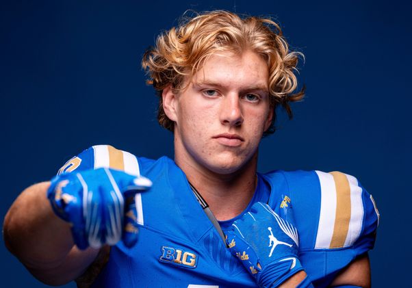 UCLA football player Carson Schwesinger points at the camera on media day