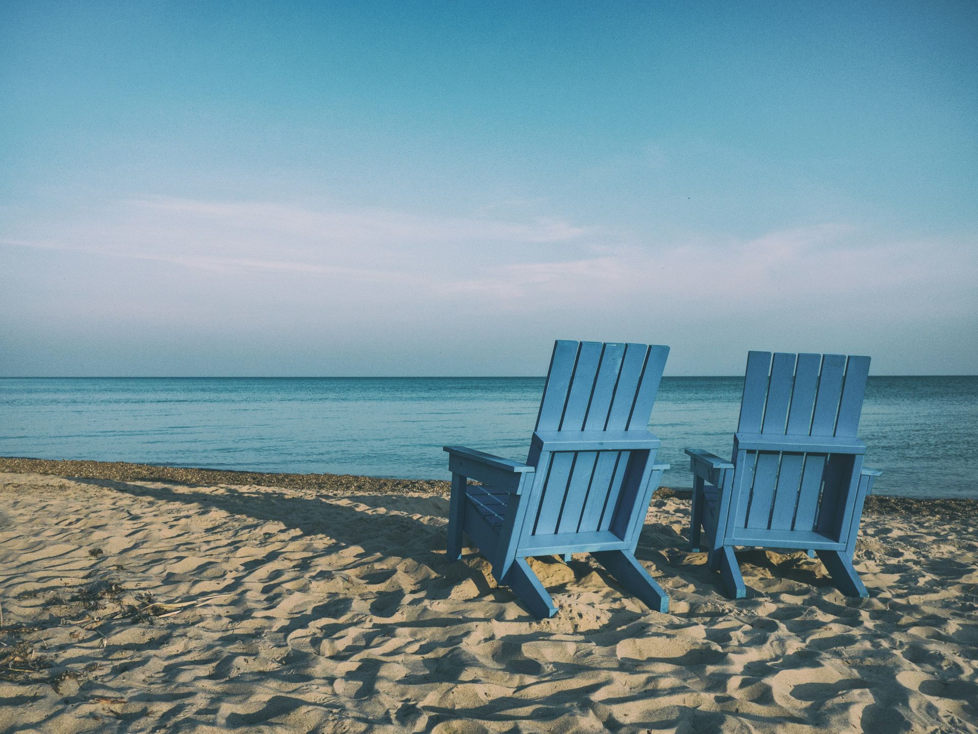 Photo | Two blue Adirondack chairs beachside in the sand | UCLA, image size:1920x1441