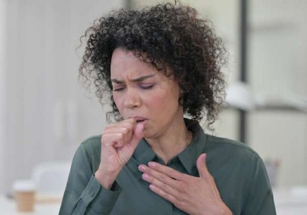 Woman coughing into hand