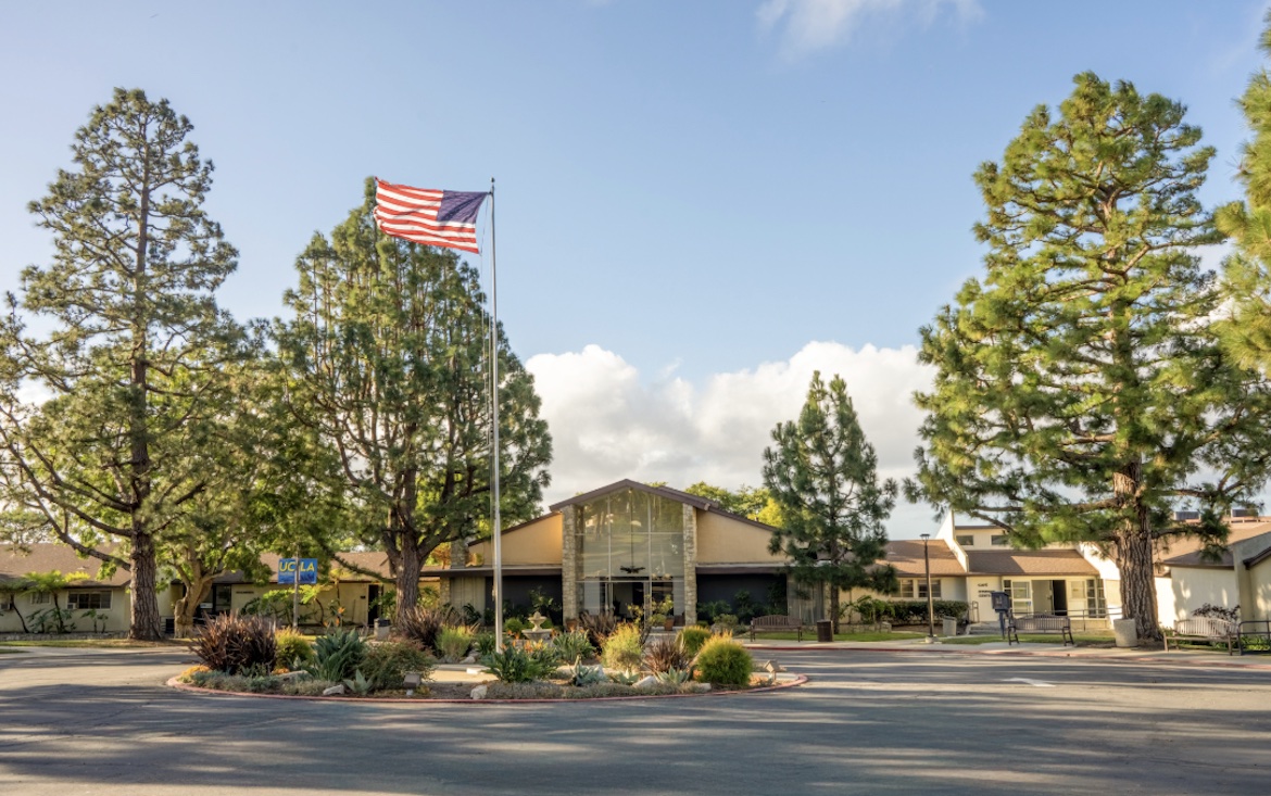 Exterior shot of UCLA South Bay in Rancho Palos Verdes, with building, flag and trees