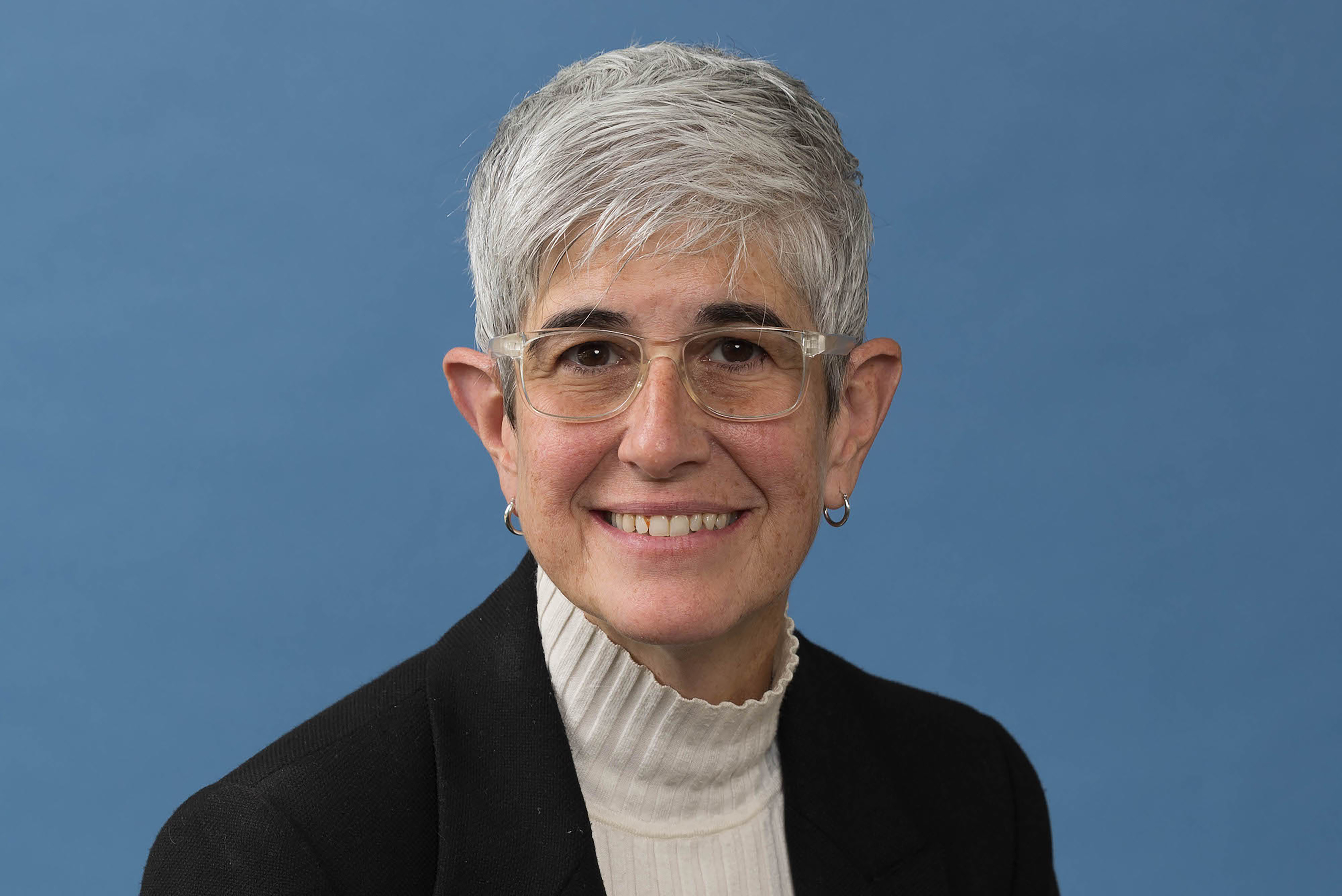 Clara Lajonchere in black jacket, white top and glasses