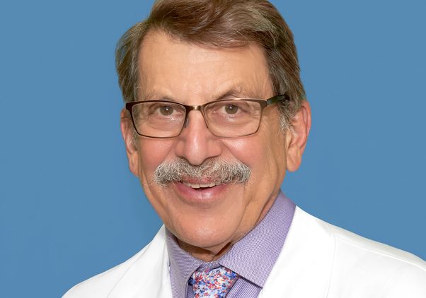 Portrait of Fred Kass in glasses, white coat and tie