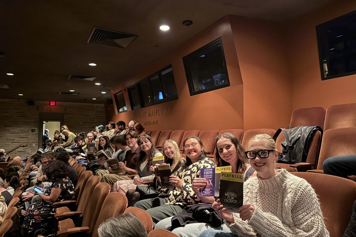 UCLA students sit in the audience of a playhouse and hold up their programs for the play "Waiting for Godot." 
