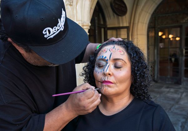 Chicano Studies Research Center assistant director Celia Lacayo gets her face painted in traditional Dia de los Muertos style.