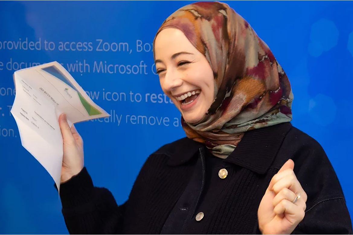 Reem Karmouta holding Match Day paper and smiling