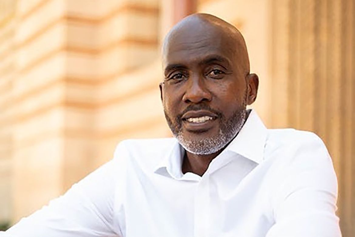Tyrone Howard sitting on steps in front of building