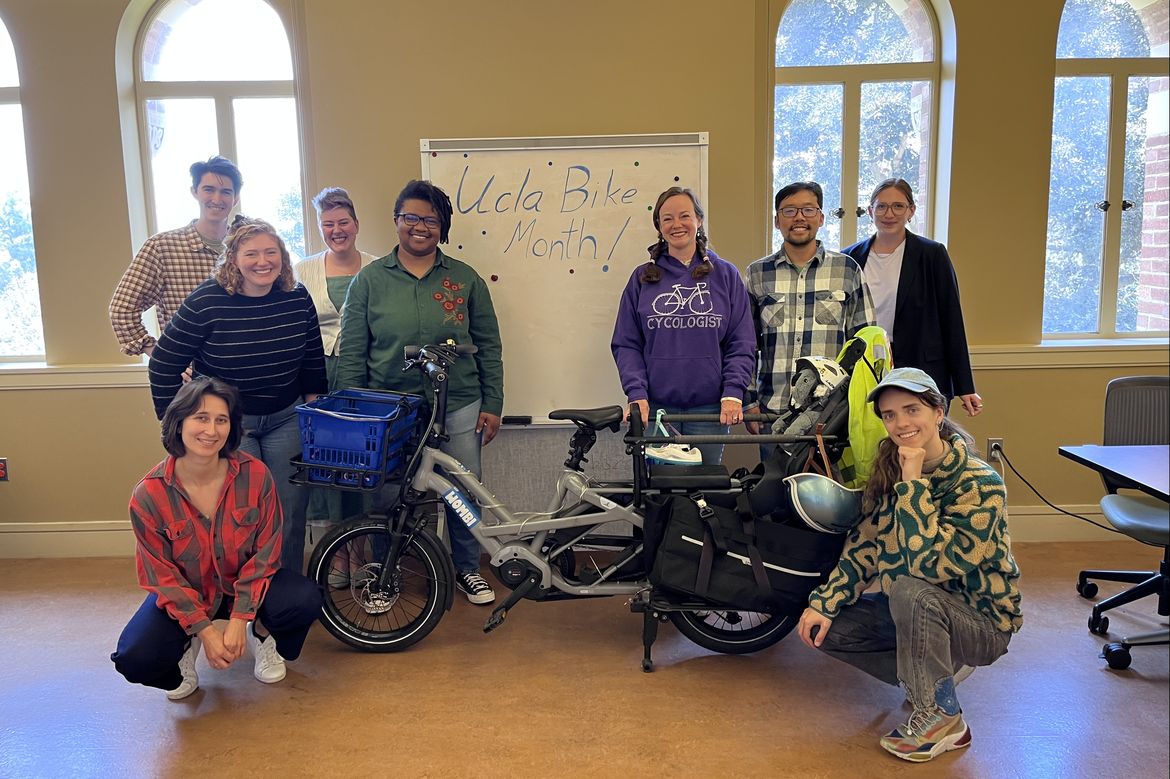 People standing around a bike and a “UCLA Bike Month” sign