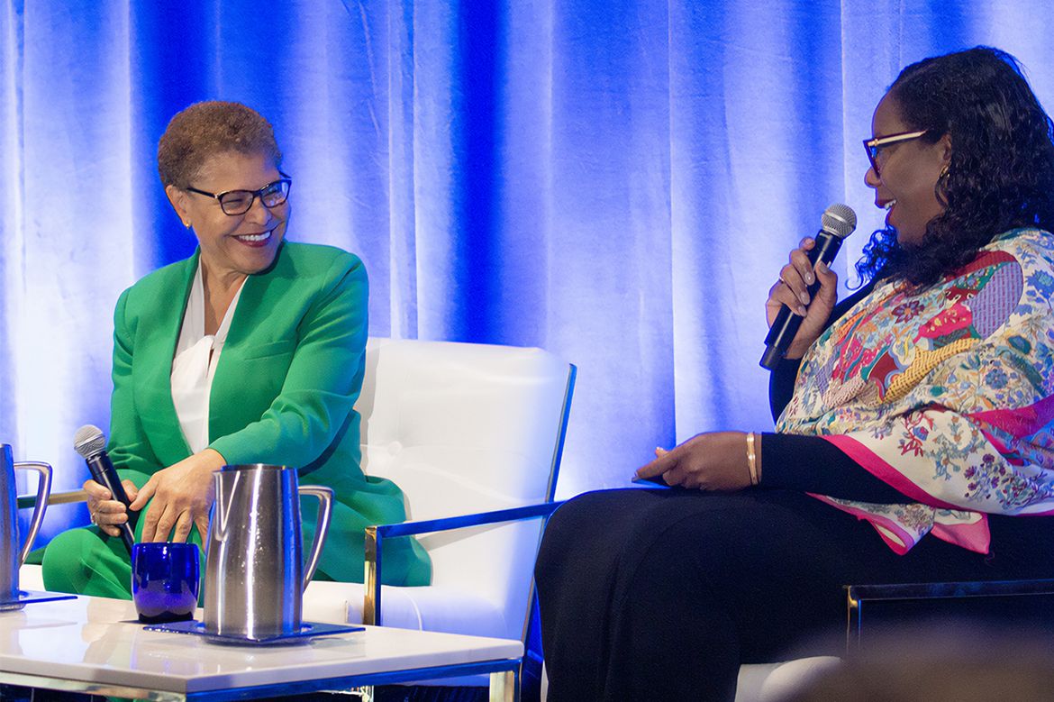 Karen Bass in green, left, speaking with Jacqueline Waggoner