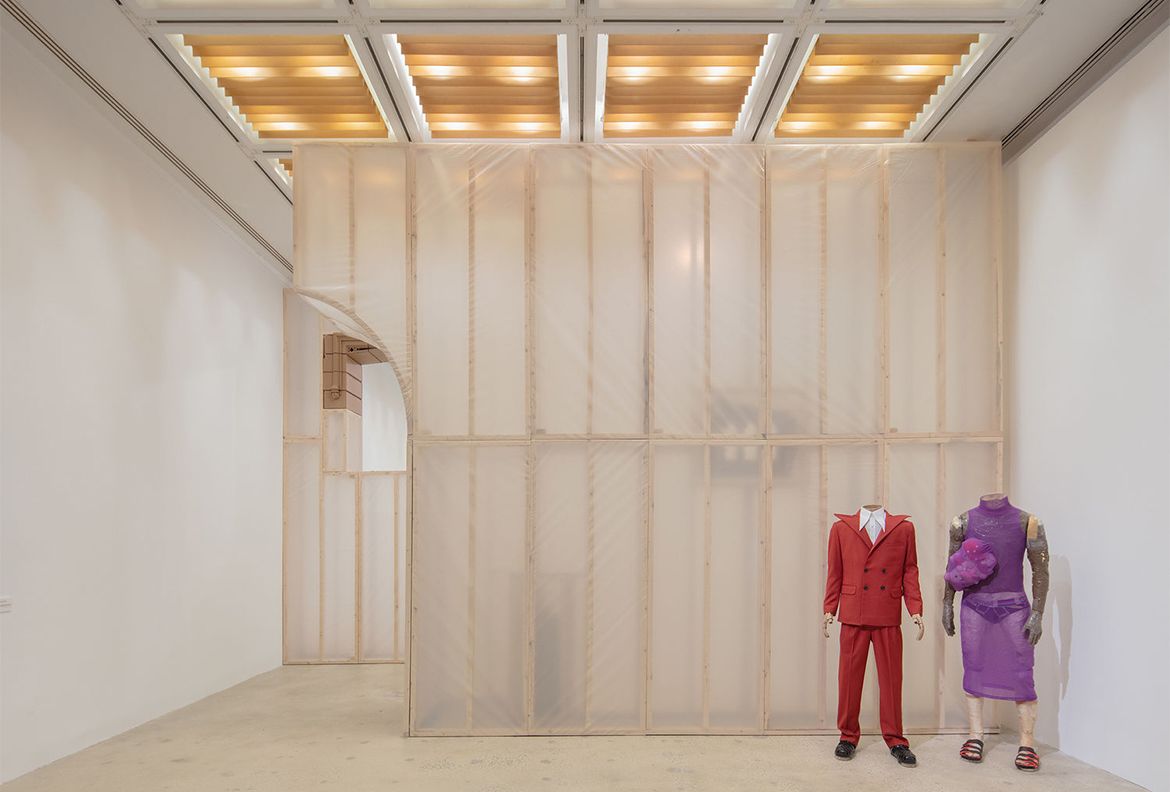 Headless mannequins wearing red suit and purple dress
