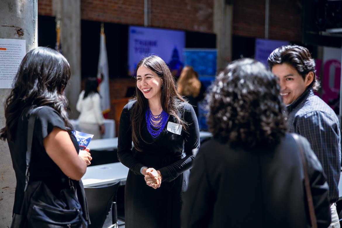 Lila Burgos in discussion with three event attendees