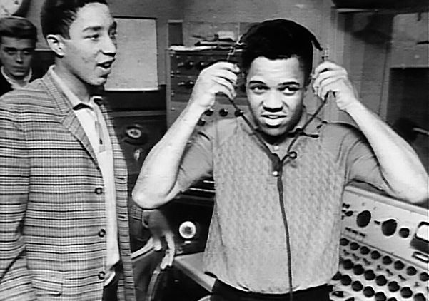 Berry Gordy, wearing headphones, in the studio with Smokey Robinson