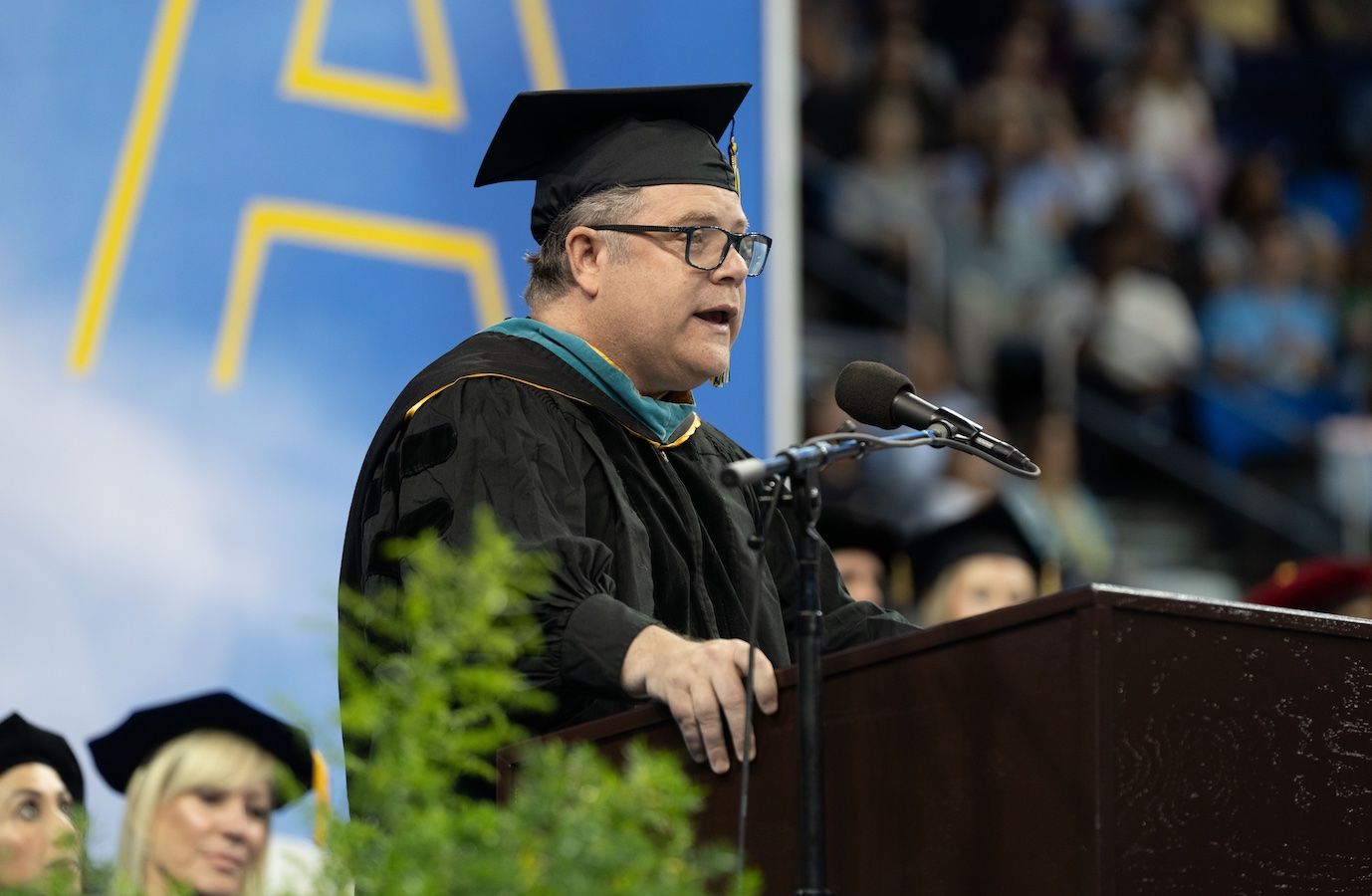 Sean Astin at podium in Pauley Pavilion