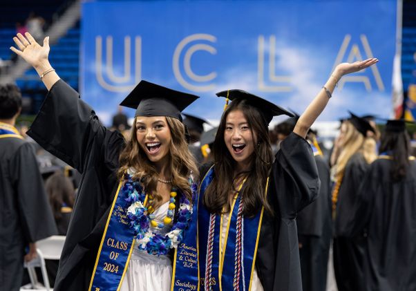 Two newly minted graduates pose for the camera
