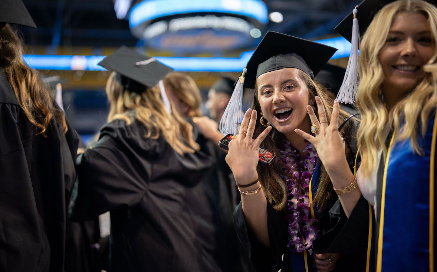Graduating student gives the fours-up in Pauley Pavilion