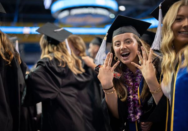 Graduating student gives the fours-up in Pauley Pavilion