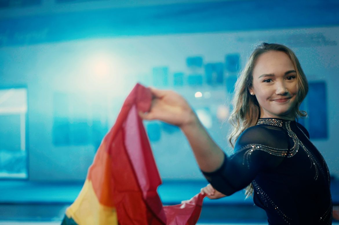 UCLA Gymnast Kalyany Steele holding a Pride flag