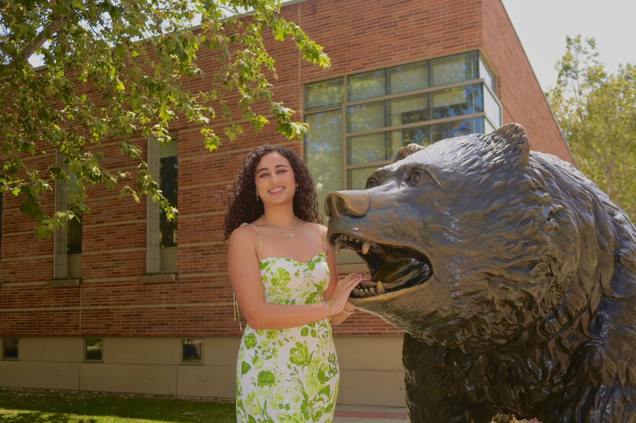 Catarina Gerges standing next to Bruin statue on campus