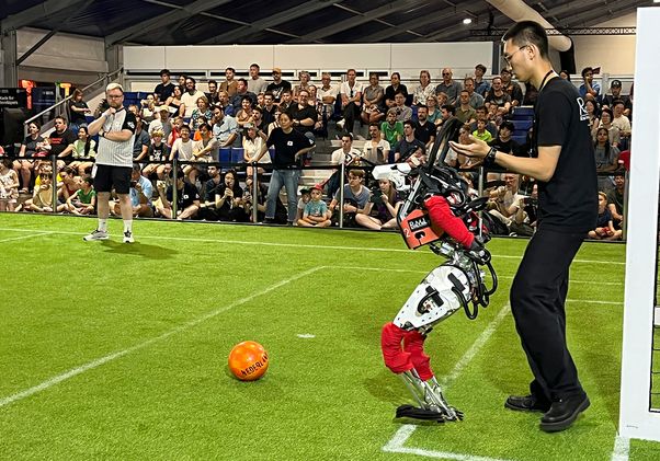 Student walking behind ARTEMIS without helping the humanoid robot
