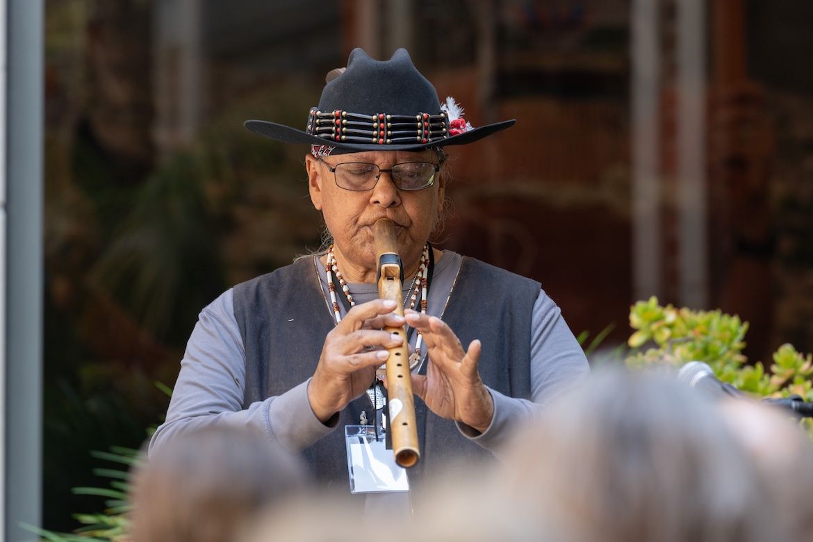 Gabrieleno/Tongva elder Michael Whitehorse Aviles wearing hat and playing flute