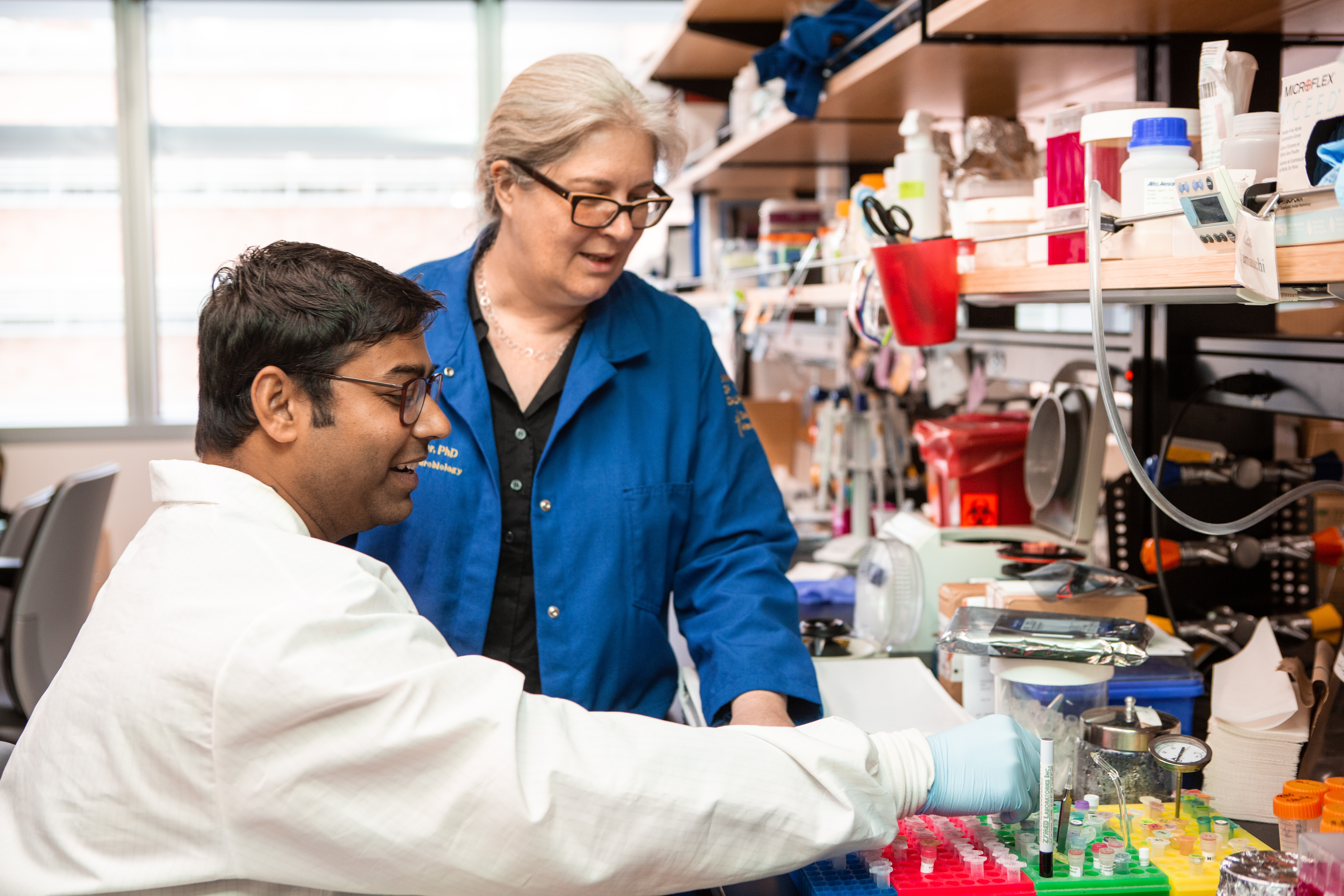 Sandeep Gupta, left, in white lab coat and Samantha Butler in blue coat