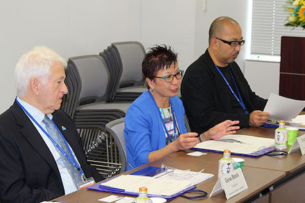 Left to right: Chancellor Block, Cindy Fan and UCLA professor Hitoshi Abe in Japan, seated at table with papers in front of them.