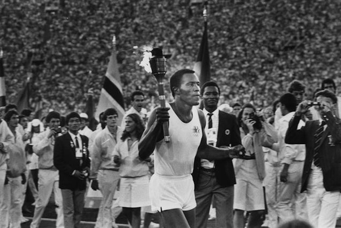 Rafer Johnson running with Olympic torch in Los Angeles in 1984 — black-and-white photo