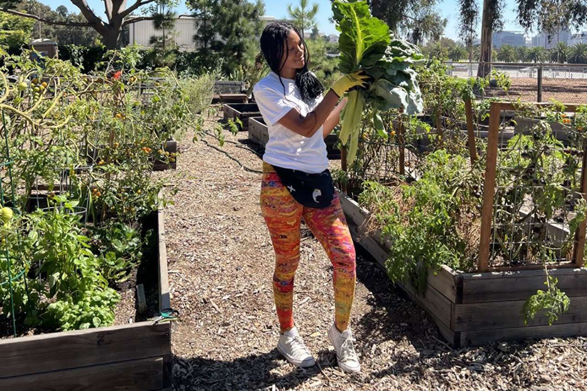 Cyntrea Cotton holds up foliage in a garden