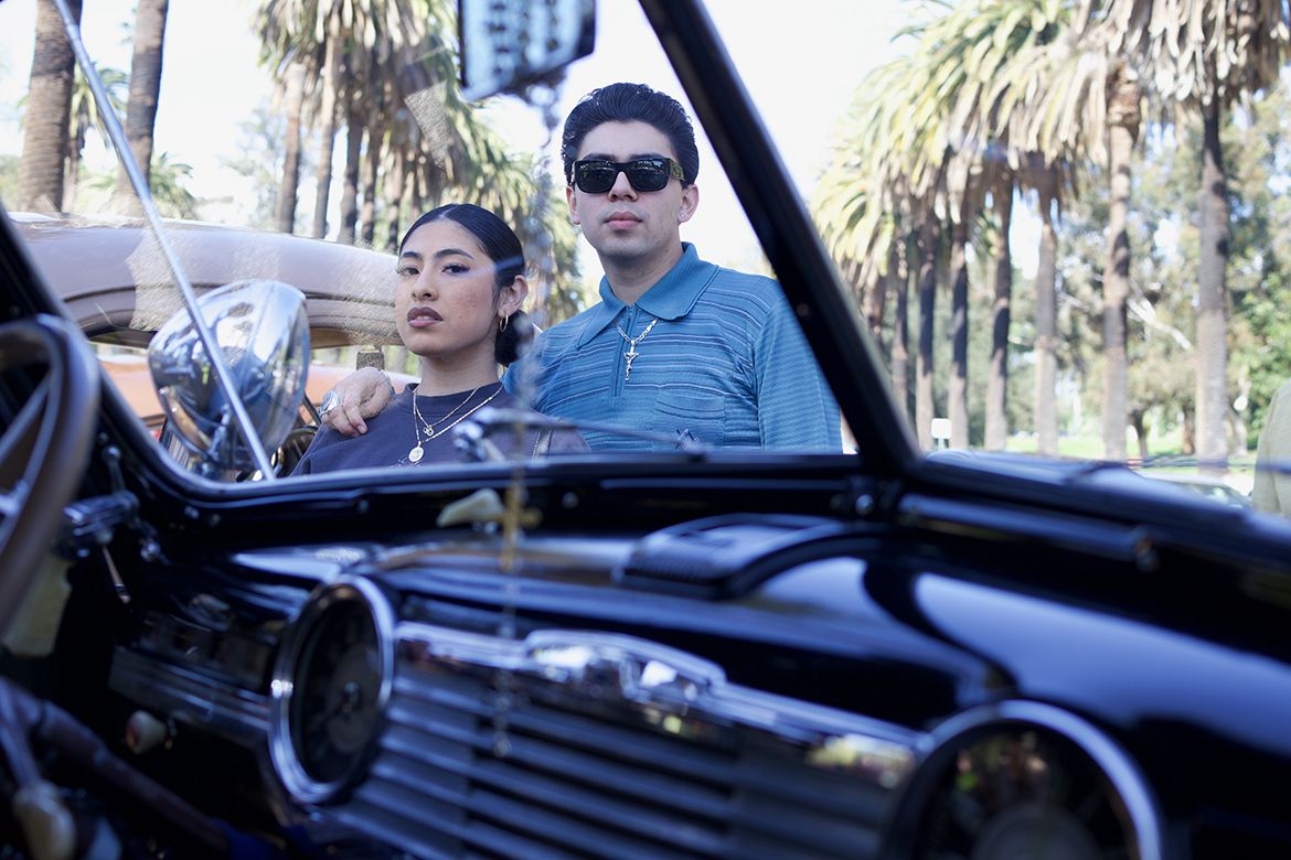A couple standing near a lowrider