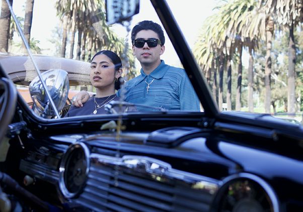 A couple standing near a lowrider