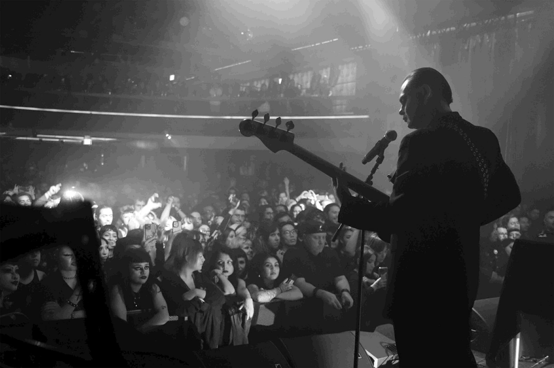 Black-and-white shot from behind of performer on stage