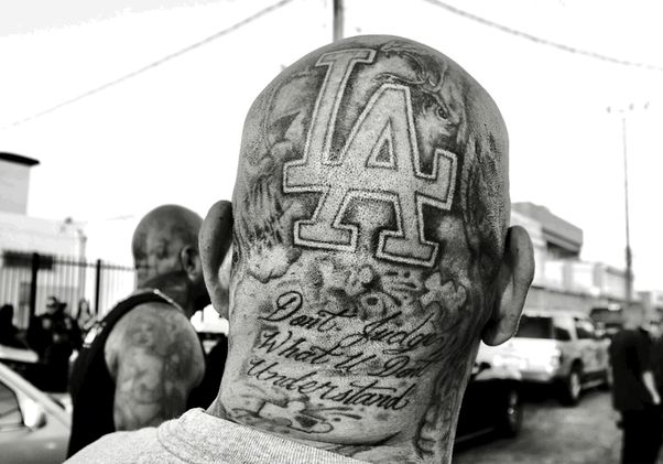Black-and-white shot of tattoo on back of man’s head reads: “LA Don’t judge what u don’t understand”