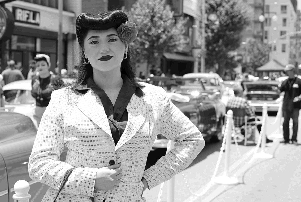Black-and-white shot of woman in light-colored jacket with flower in hair