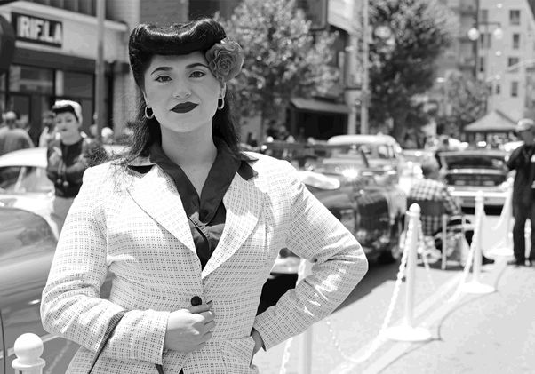 Black-and-white shot of woman in light-colored jacket with flower in hair