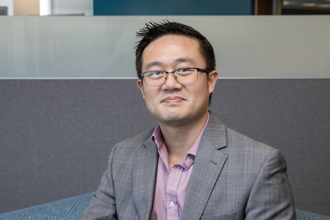 UCLA Chief Security Officer Drake Chang seated in office with gray sport coat