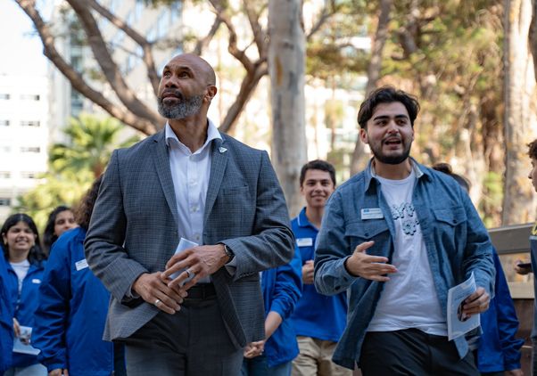 Darnell Hunt walking with students during move-in, 2024