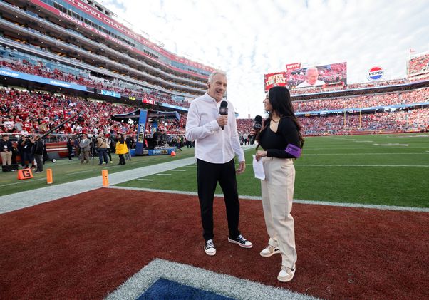 Lindsey Pallares speaking with Joe Montana on football field