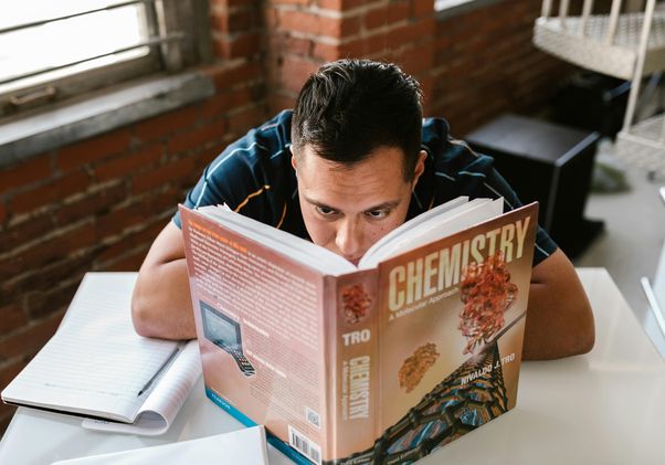 Student reading a chemistry textbook