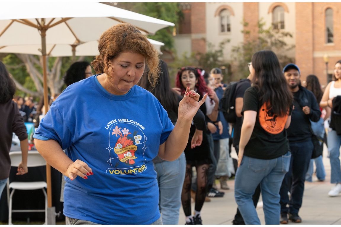 Elva Neyoy, a parent volunteer for the 2024 Latinx Welcome, dances in Wilson plaza with others to DJ music. 