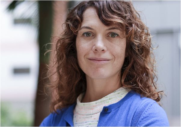 Amy Rowat, arms crossed, in blue cardigan